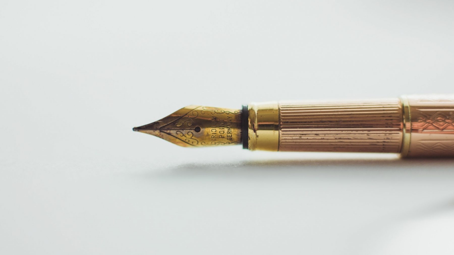 Golden Pen on White Paper